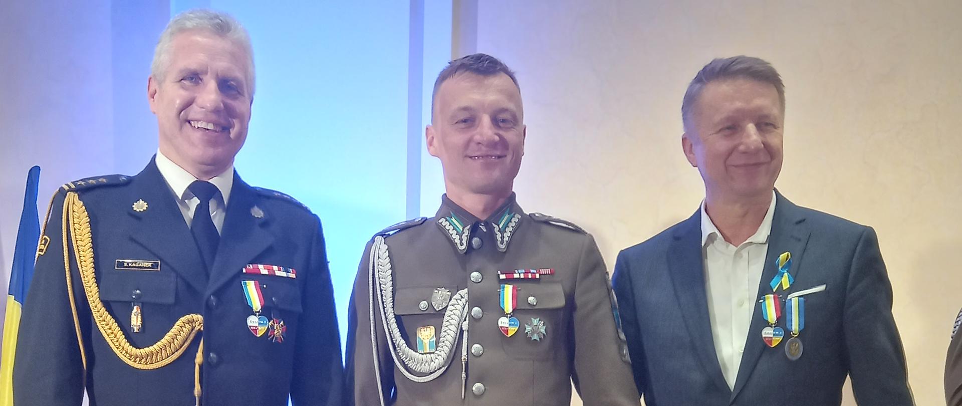 Zdjęcie przedstawia trzy osoby odznaczone medalem "Sercem z Ukrainą"