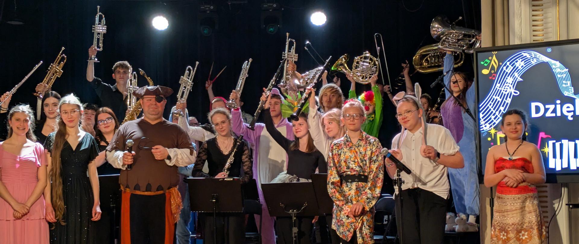 Wszyscy wykonawcy stoją na scenie.