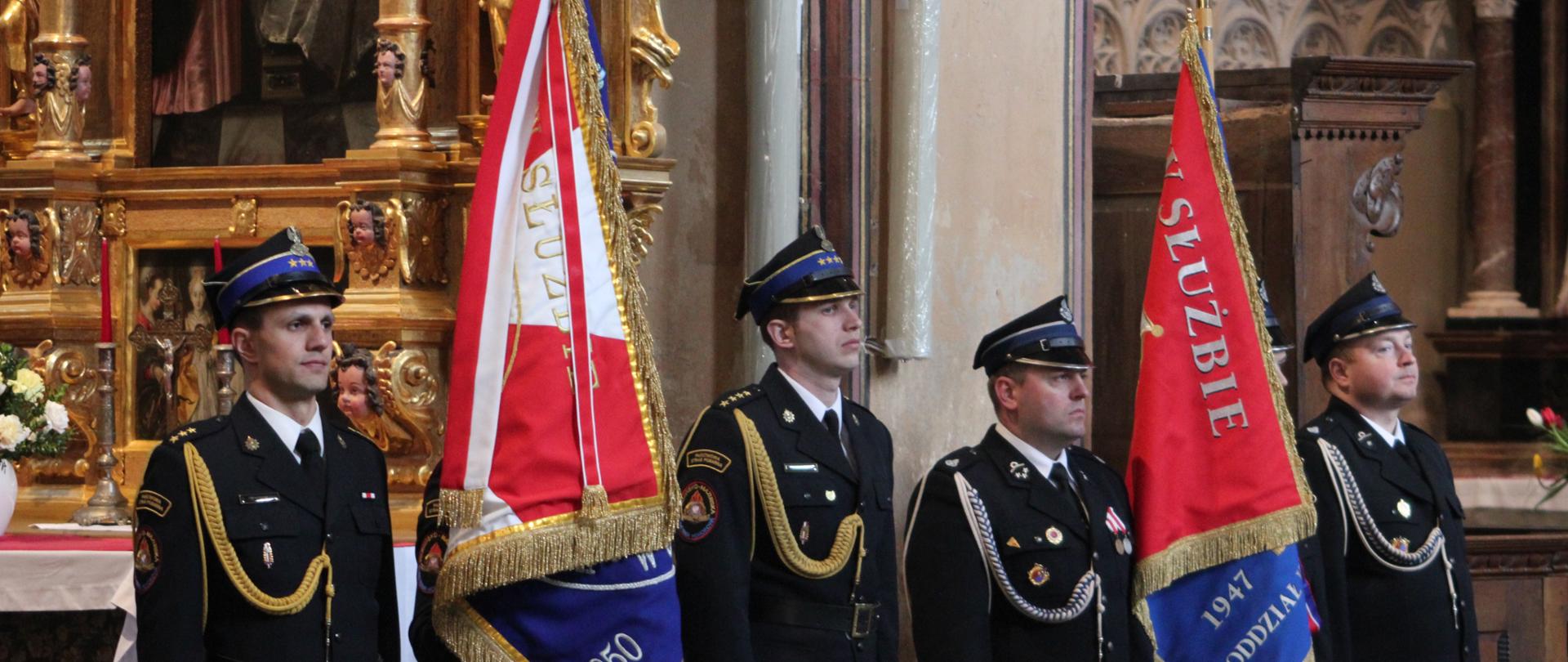 Strażacy stoją ze sztandarami