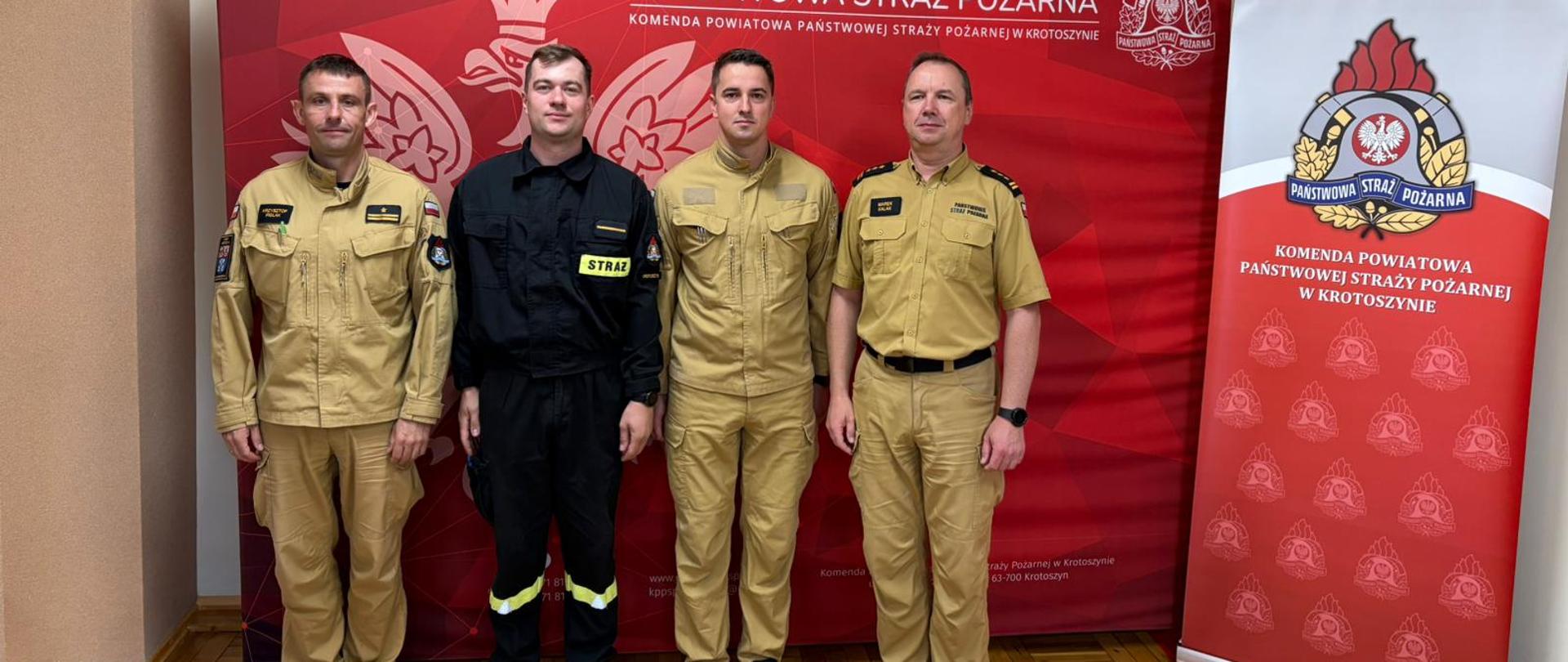 zdjęcie przedstawia awansowanych funkcjonariuszy wraz ze swoimi przełożonymi na tle logo PSP w świetlicy KP