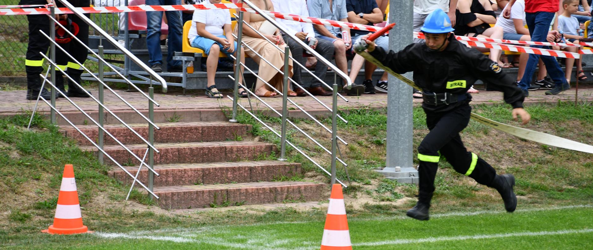 Na zdjęciu widzimy strażaka OSP wbiegającego na linię mety.