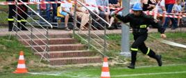 Na zdjęciu widzimy strażaka OSP wbiegającego na linię mety.