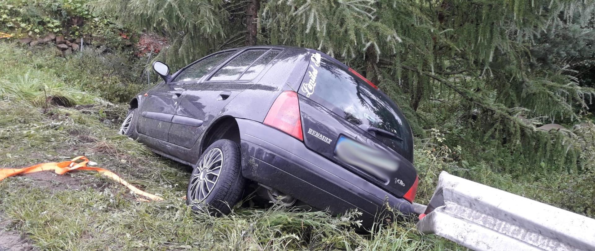 Widok od tyłu samochodu osobowego opartego o barierki energochłonne.