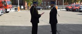 Zdjęcie przedstawia pomorskiego komendanta wojewódzkiego PSP st. bryg. Piotra Sochę wręczającego decyzję o powierzeniu obowiązków zastępcy komendanta powiatowego PSP w Kościerzynie st. kpt. Rafałowi Duzowskiemu. 