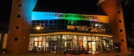 Nocne zdjęcie oświetlonego budynku muzeum od strony wejścia głównego