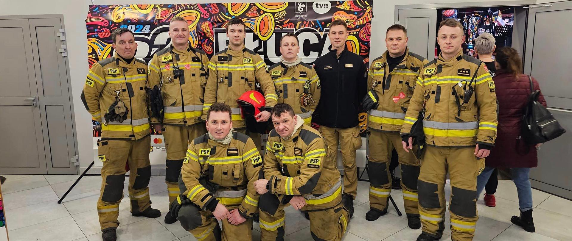 Zdjęcie przedstawia strażaków Komendy Powiatowej Państwowej Straży Pożarnej w Radziejowie ubranych w ubrania specjalne koloru piaskowego, którzy brali udział w pokazie z zakresu ratownictwa technicznego na terenie RDK w Radziejowie