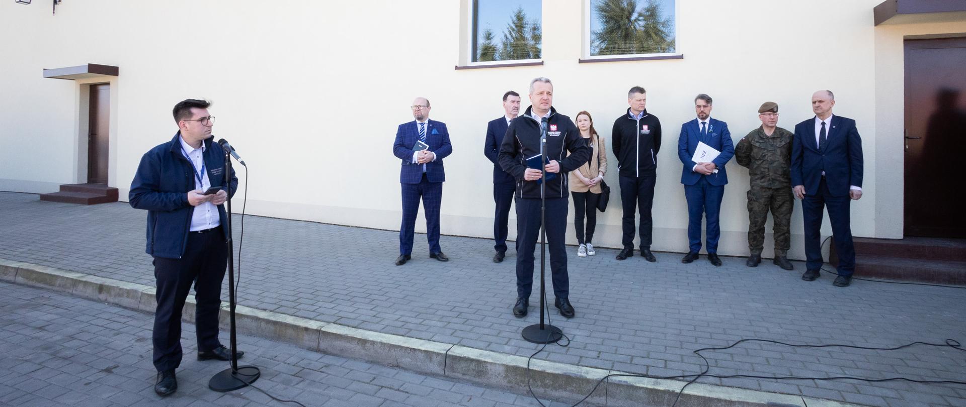 7 osób stojących na tle jasnej ściany