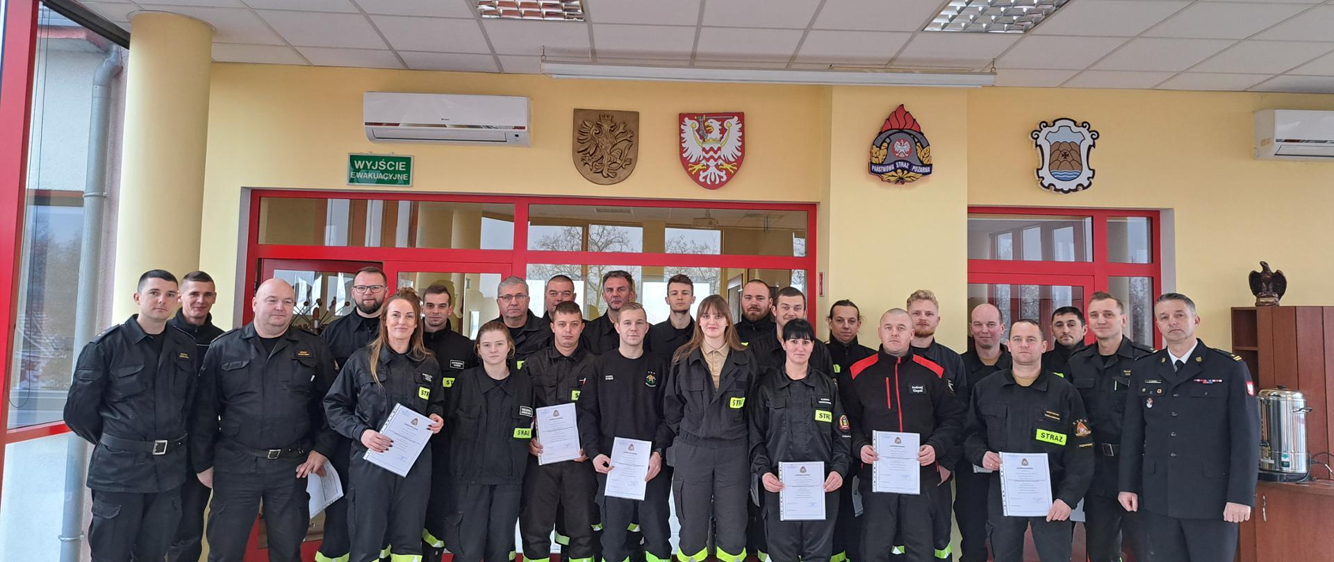 Na zdjęciu znajdują się uczestnicy szkolenia dla kierujących działaniem ratowniczym dla strażaka ratownika OSP, zdjęcie wykonano w Sali sztabowej KP PSP w Chełmnie podczas wspólnego zdjęcia po zakończonym egzaminie. 