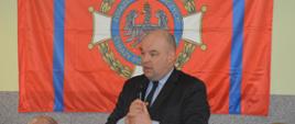 Zebranie sprawozdawcze OSP Ostoje. Świetlica wiejska w Ostojach. Na tle flagi ZOSP RP przemawia minister Jan Dziedziczak. 