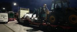 Od lewej: tył oznakowanego furgonu mazowieckiej Inspekcji Transportu Drogowego. Obok, tuż za radiowozem ITD, stoi zatrzymany ciągnik siodłowy z podpiętą naczepą niskopodwoziową. 40-tonowy zestaw przewozi koparko – ładowarkę, minikoparkę, pięć worków Big Bag z kostką brukową oraz paletę krawężników.