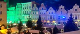 Opolski Rynek nocą. Na rynku choinki i stragany ozdobione światełkami.