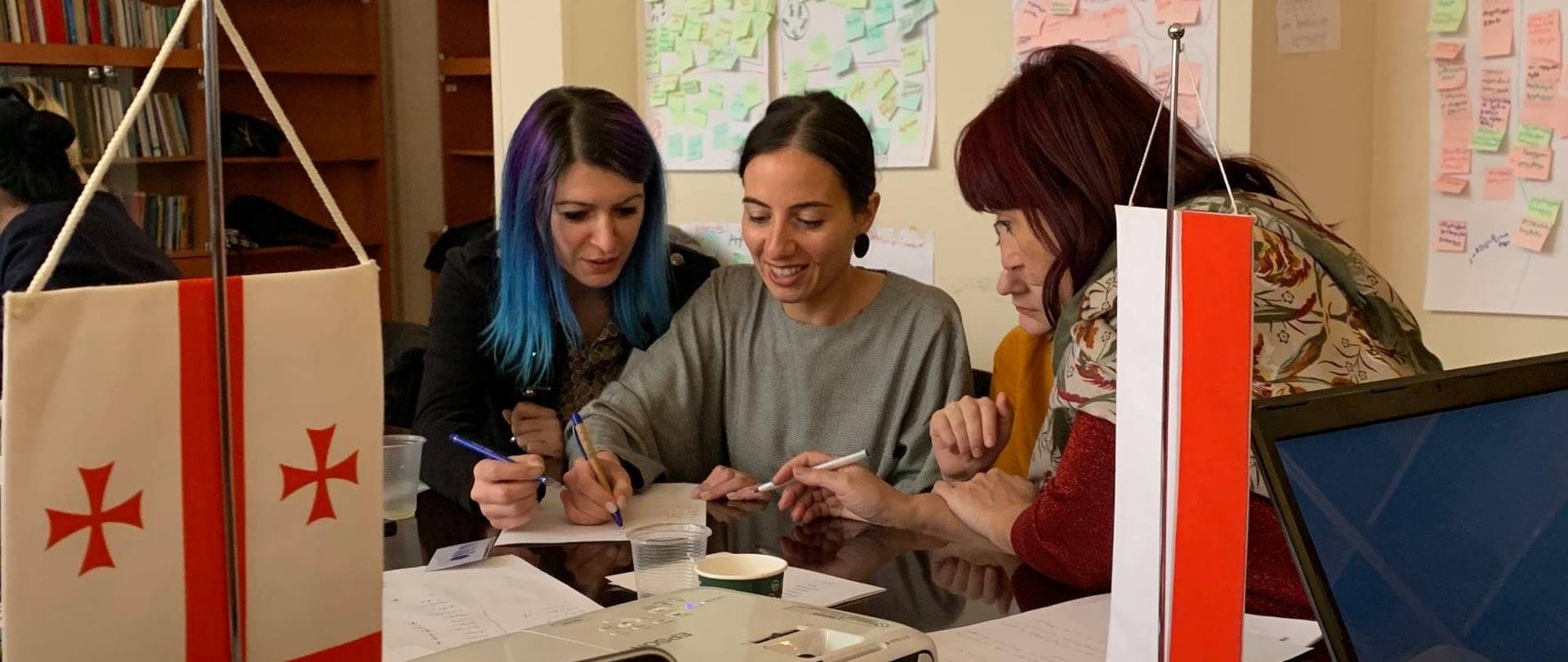 grupa 4 kobiet rozmawia i zapisuje na kartce