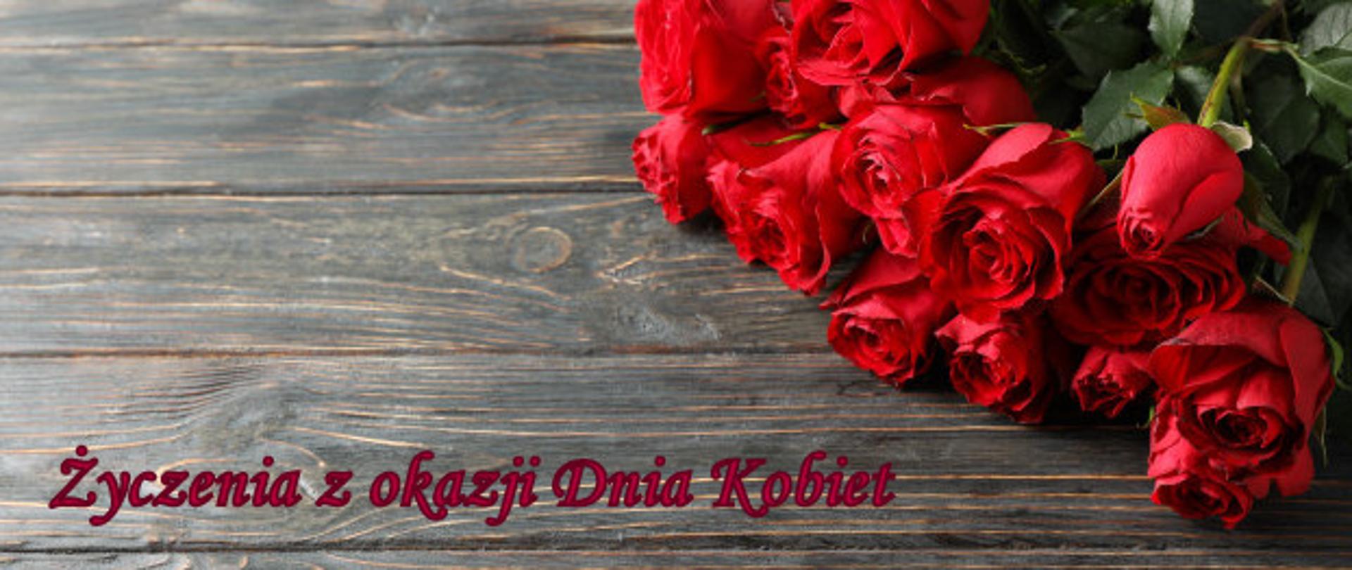 czerwone róże na brązowych deskach, napis życzenia z okazji dnia kobiet