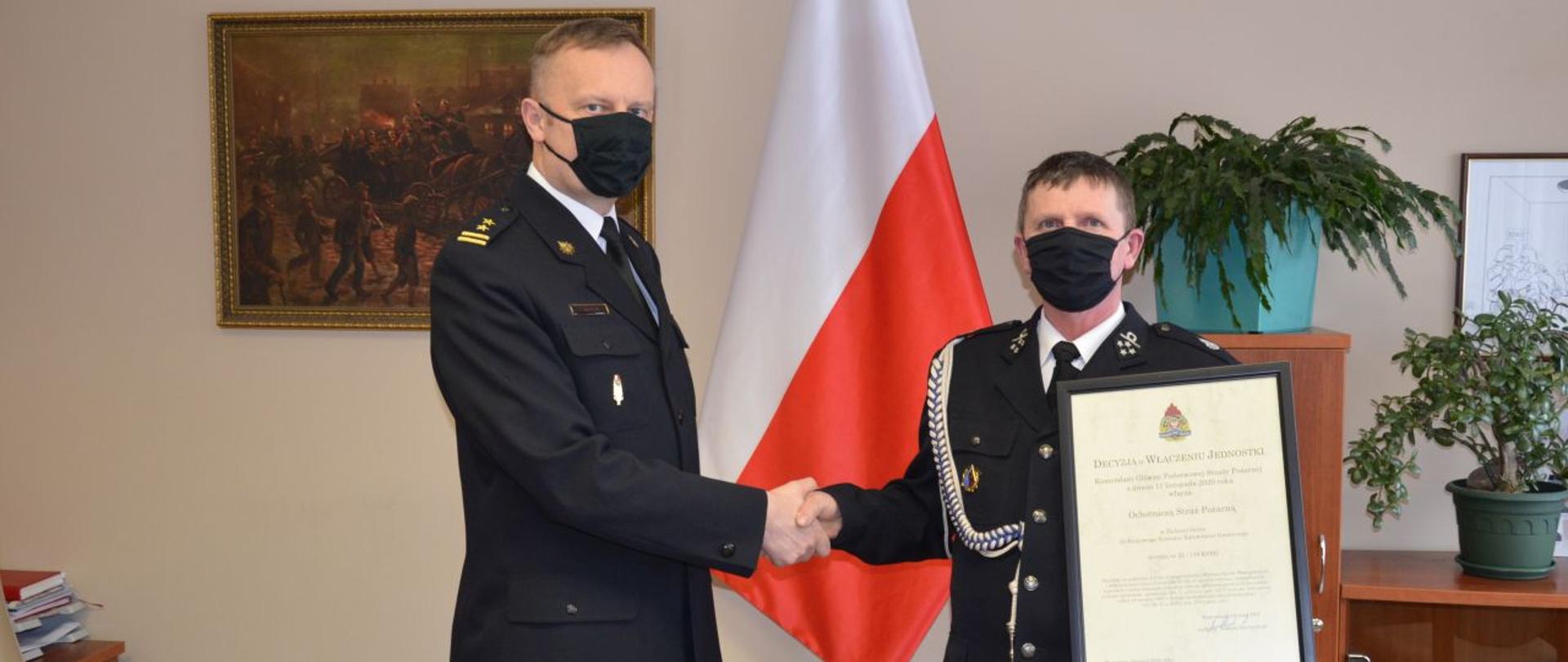 foto przedstawia Komendanta Powiatowego podczas wręczania decyzji