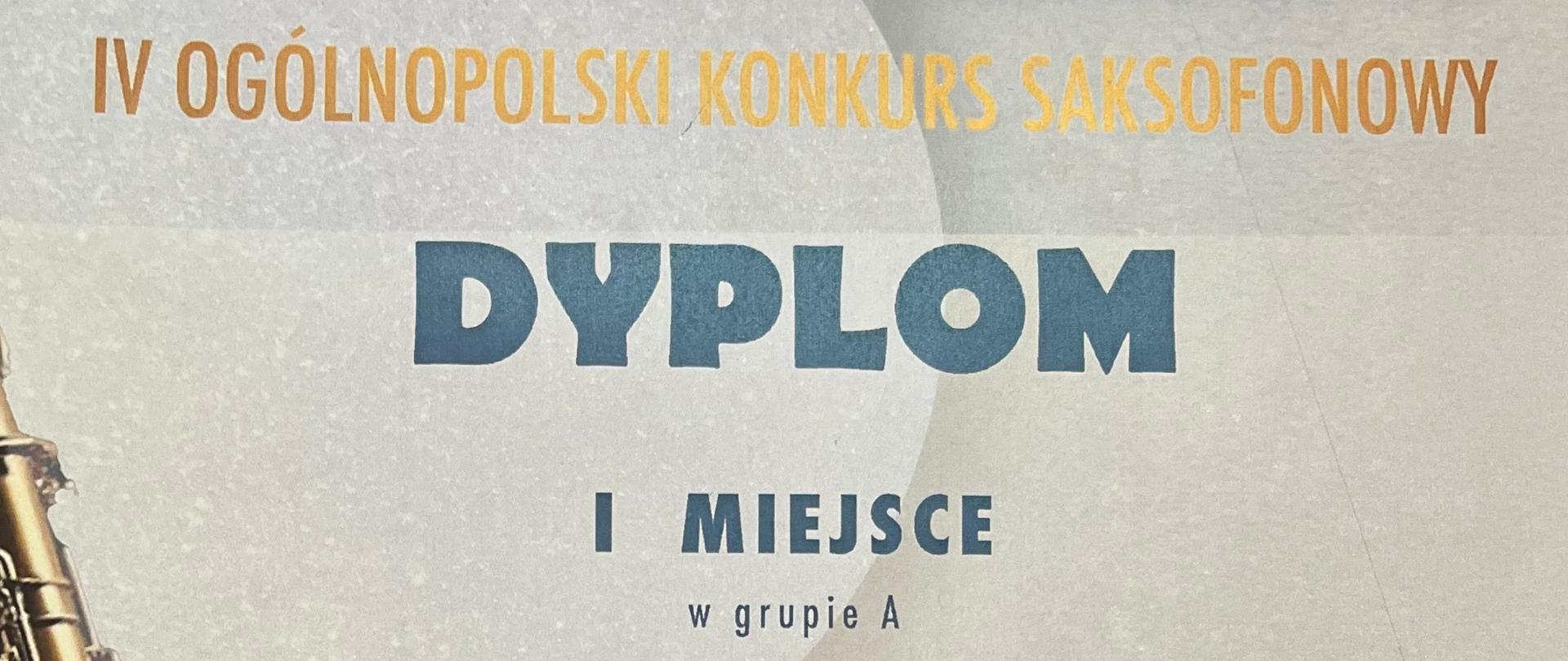 Zdjęcie dyplomu przyznanego Alicji Komosińskiej za zajęcie I miejsca w grupie A podczas IV Ogólnopolskiego Konkursu Saksofonowego, który odbył się 22 maja 2025 roku w Zespole Szkół Muzycznych im. Stanisława Moniuszki w Łodzi. Na dyplomie znajdują się dane szkoły uczennicy: PSM I st. im. J. S. Bacha w Grajewie, a także imiona nauczyciela – Michał Kalinowski i pianistki – Magdalena Borkowska.W tle dyplomu widoczny jest ozdobny motyw z saksofonem na niebieskim kole z cienkimi złotymi liniami.
