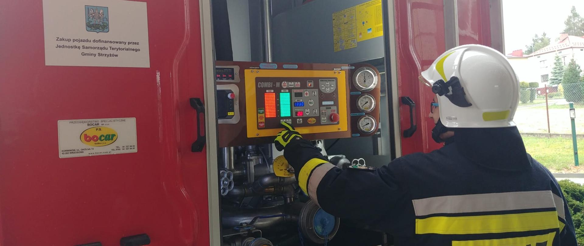 Na zdjęciu druh OSP podczas obsługi autopompy samochodu pozarniczego.