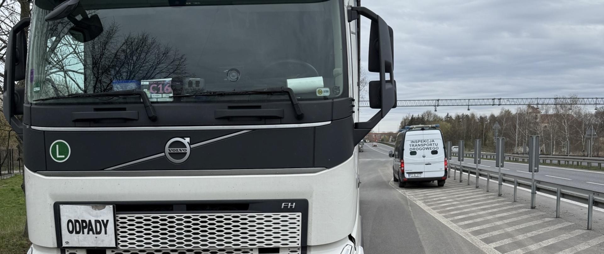 Na zdjęciu widoczny pojazd przewożący odpady, za nim w tle pojazd Inspekcji Transportu Drogowego w Poznaniu.