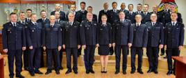 kilkudziesięciu strażaków w mundurach pozują do zdjęcia w sali konferencyjnej