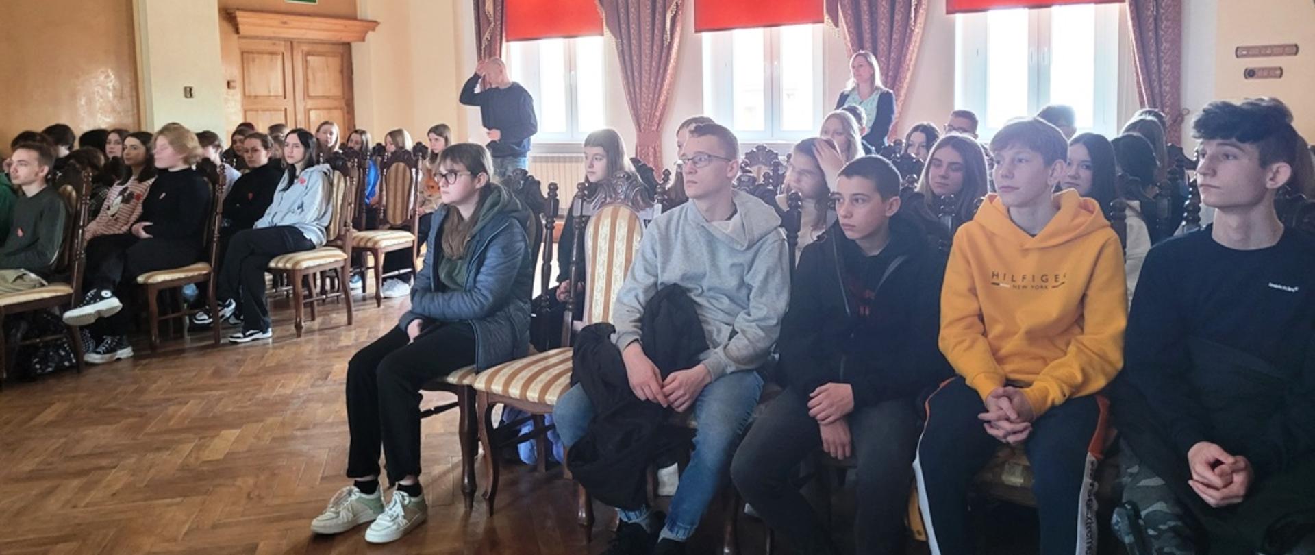 Zdjęcia przedstawiają prelegentów i uczniów podczas spotkania