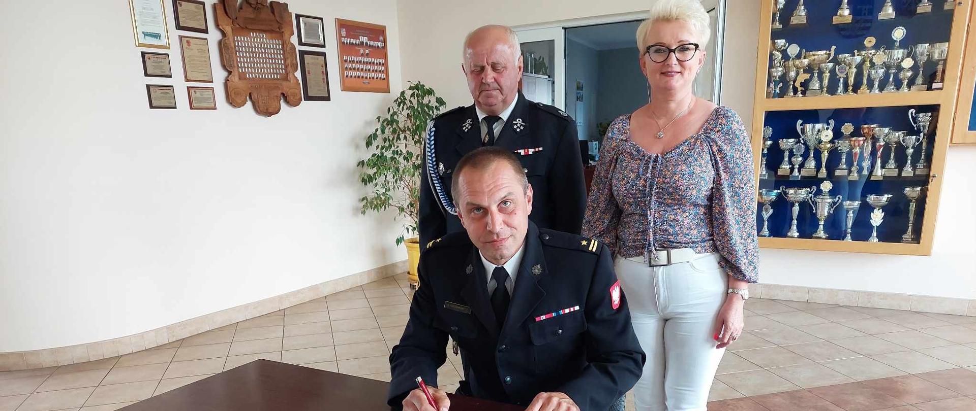 Zdjęcie przedstawia Komendanta Powiatowego PSP podpisującego porozumienie. W tle Wójt Gminy Sadowie oraz Prezes OSP Wszechświęte.