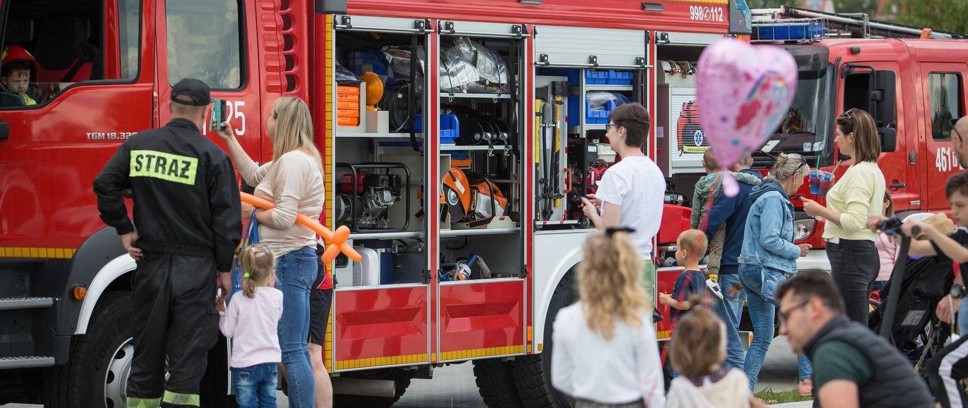Zdjęcie przedstawia dzieci wraz opiekunami podczas oglądania wyposażenia wozu bojowego
