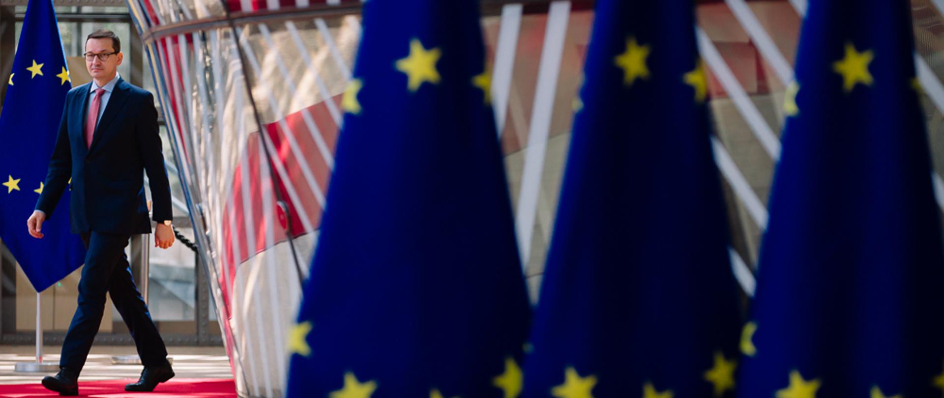 Premier idzie, z przodu flagi UE.
