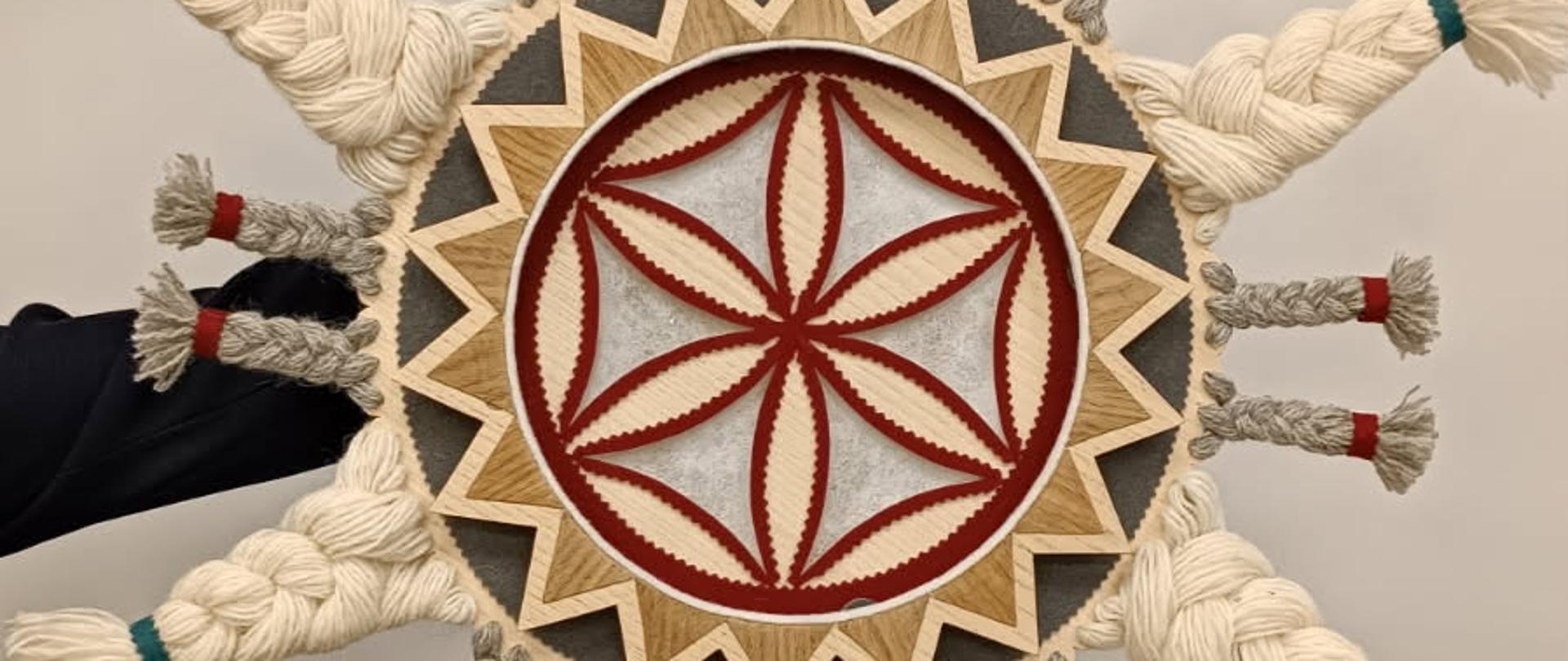 Na zdjęciu widzimy świąteczną gwiazdę zaprojektowaną i wykonaną przez Ewę Ross-Baczyńska, nauczycielkę rzeźby w PLSP im. A. Kenara w Zakopanem. Gwiazda jest kolorowa wykonana z drewna i wełnianych elementów.