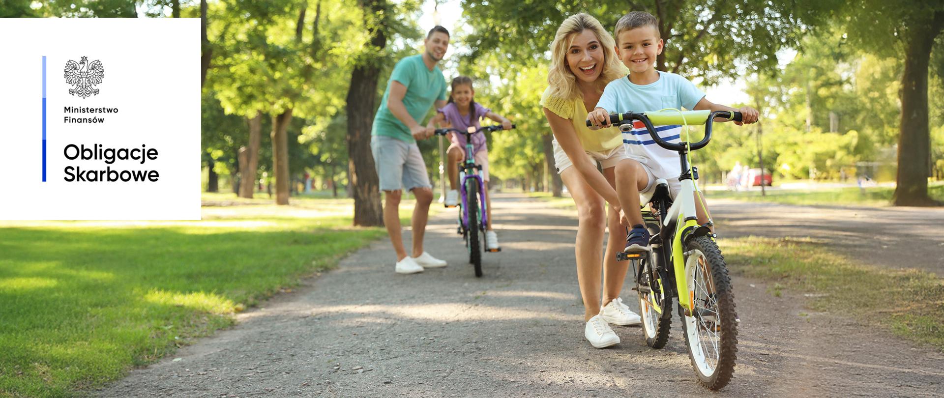 Kobieta i mężczyzna, dzieci na rowerach. Ministerstwo Finansów, Obligacje Skarbowe.