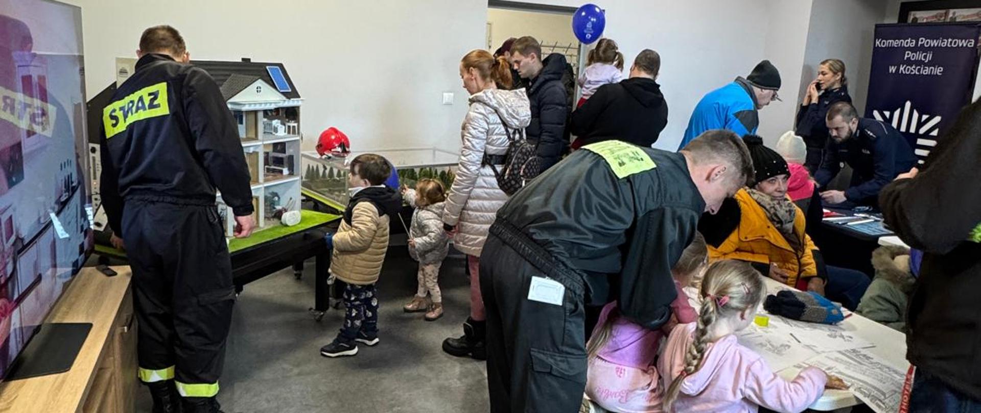 „Otwarta strażnica” w kościańskiej komendzie. Strażacy i Goście podczas akcji „Otwarta strażnica” w siedzibie kościańskiej komendy. Goście zwiedzają strażnicę, oglądają pojazdy, sprzęt i umundurowanie. Osoby biorą udział w pokazach sprzętu, ćwiczeniach z zakresu pierwszej pomocy. 