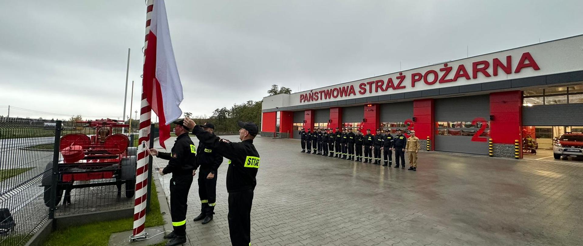 Na zdjęciu strażacy przed budynkiem Komendy Powiatowej PSP w Wieliczce podczas uroczystego podnoszenia flagi państwowej na maszt