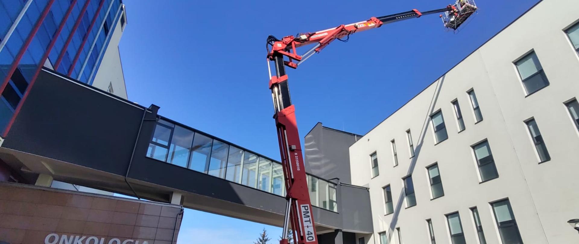 Podnośnik hydrauliczny rozstawiony przy budynku szpitala