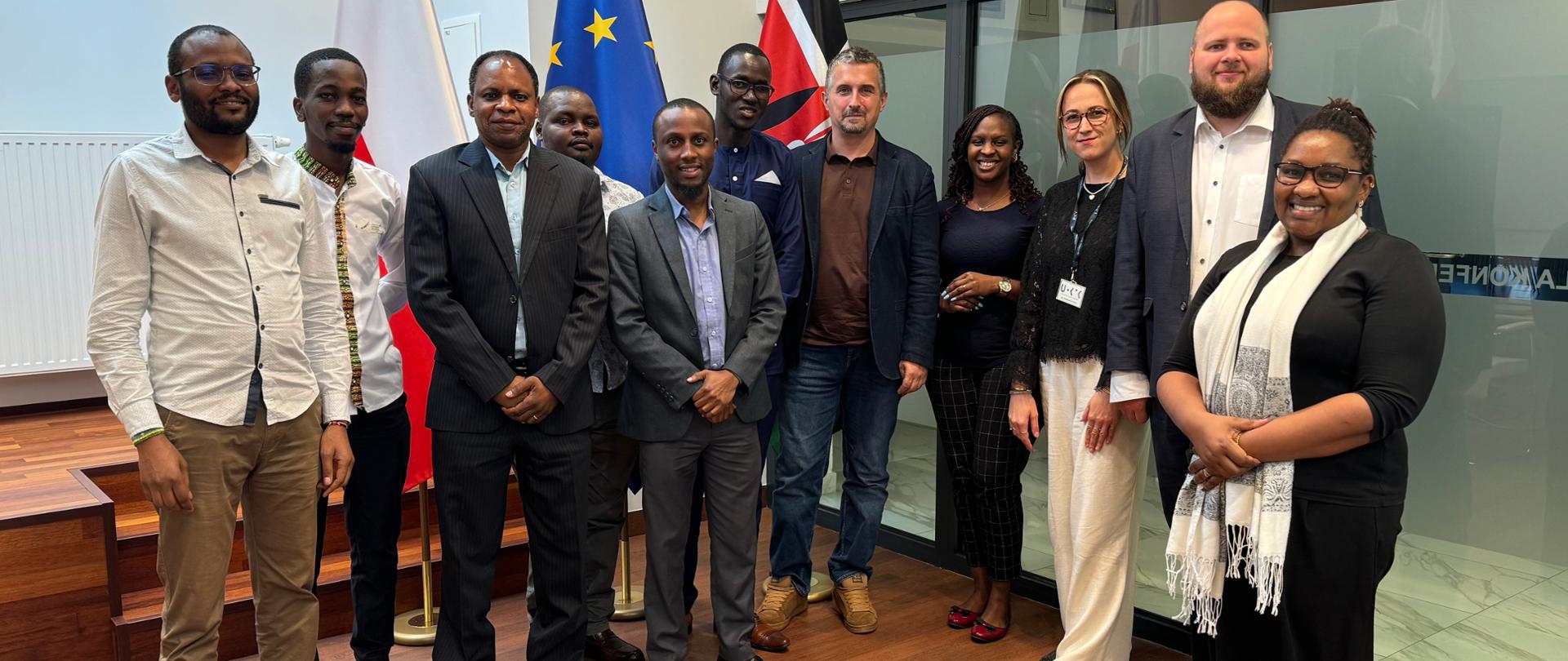 Grupa osób pozuje do zdjęcia w sali konferencyjnej