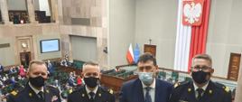Kierownictwo Komendy Głównej Państwowej Straży Pożarnej na balkonie w sejmie. Za plecami widoczna sala plenarna i obradujący posłowie
