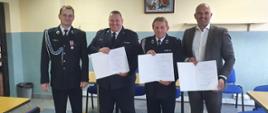 Komendant Miejski PSP w Łomży, wójt gminy Piątnica oraz przedstawiciele włączanych podmiotów ratowniczych OSP w Olszynach trzymają podpisane porozumienie