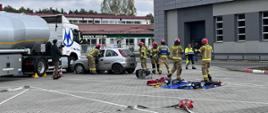 Zdjęcie przedstawia realizację założenia ćwiczebnego z ratownictwa technicznego z elementami ratownictwa chemicznego, w którym doszło do zderzenia samochodu osobowego z samochodem ciężarowym typu cysterna przewożącym olej napędowy.