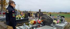 Funkcjonariusze stoją nad mogiłą.