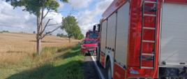 Samochody pożarnicze stoją na drodze.