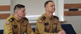 16 lutego 2026 r. w Komendzie Powiatowej Państwowej Straży Pożarnej w Zambrowie odbyła się narada roczna podsumowująca funkcjonowanie krajowego systemu ratowniczo-gaśniczego w powiecie zambrowskim w 2025 roku - na zdjęciu przy biurku komendant powiatowy i zastępca podlaskiego komendanta wojewódzkiego PSP