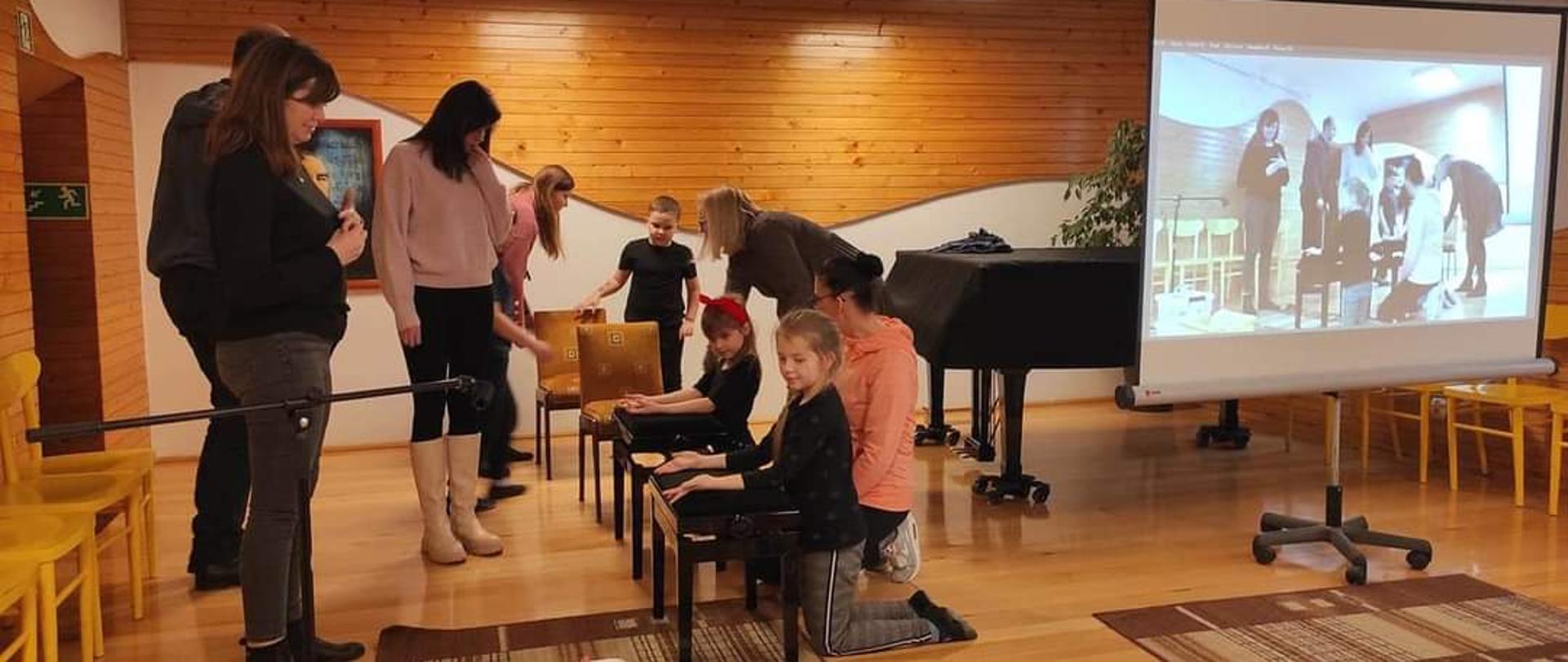 Uczniowie wykonujący ćwiczenia manualne w obecności rodziców pod kierunkiem terapeutek