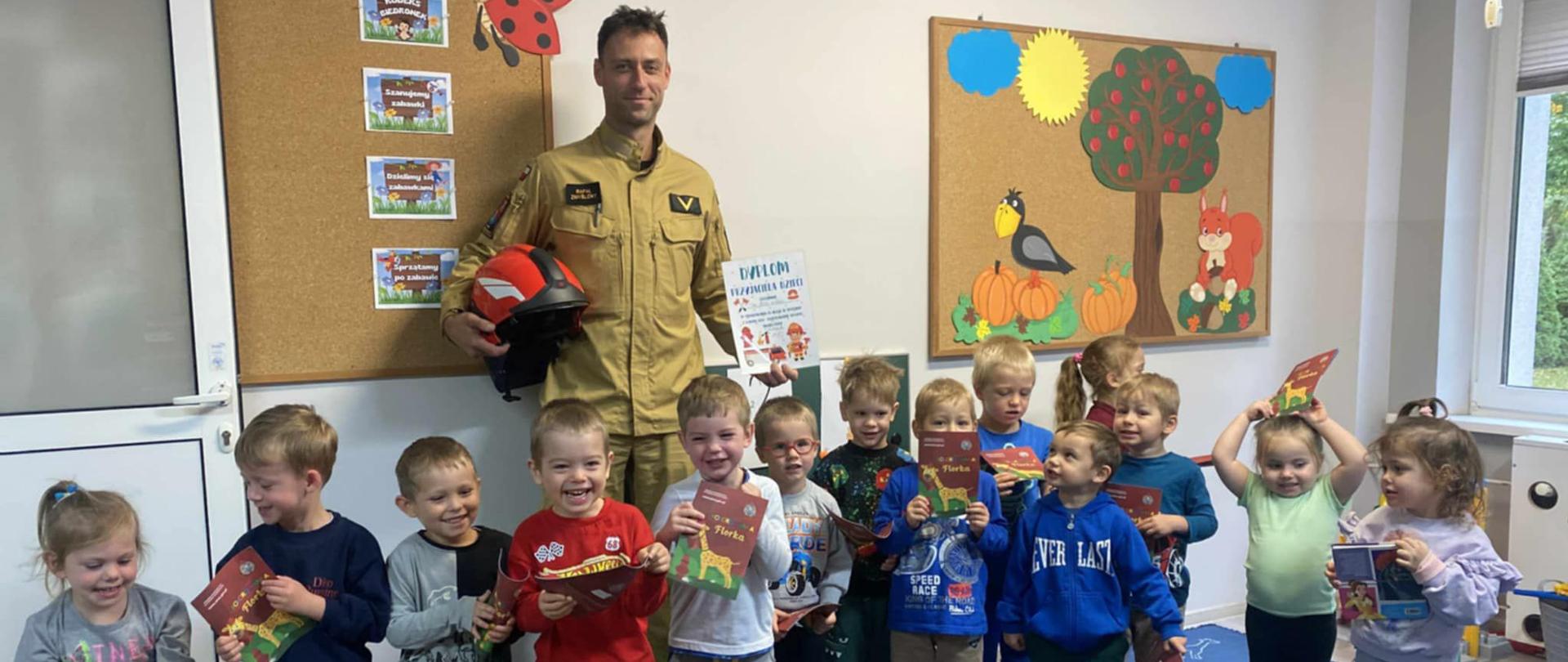 Strażak na zdjęciu wspólnie z dziećmi.