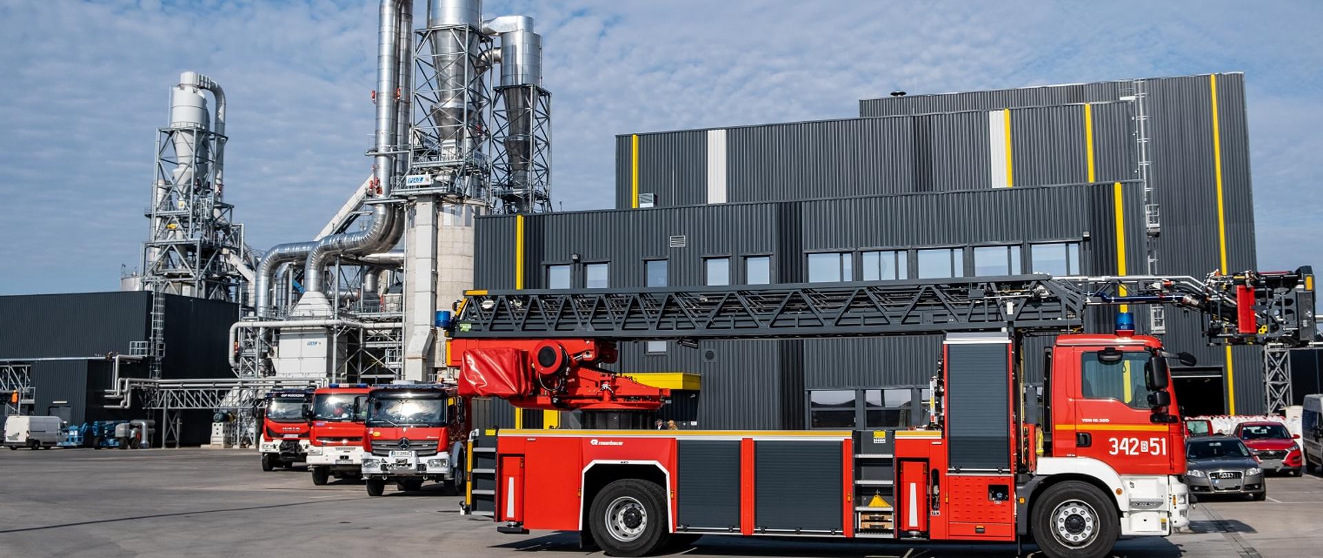Na zdjęciu widać samochody pożarnicze w tle budynki fabryki