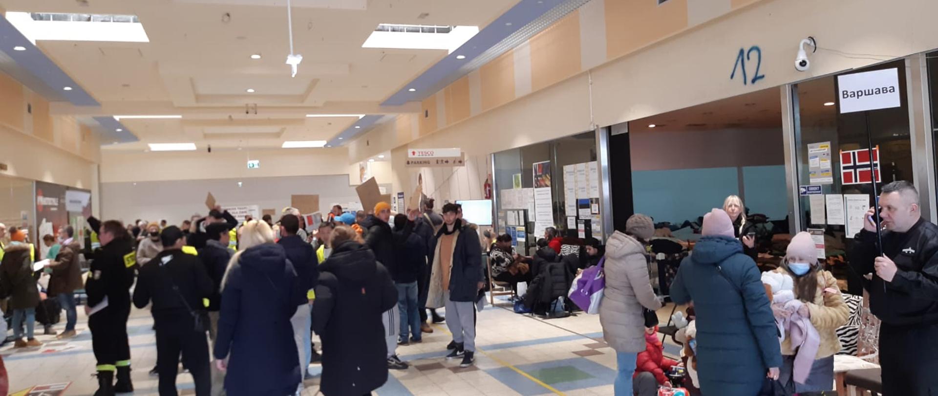 ZDJĘCIE WYKONANE WEWNĘTRZ POMIESZCZENIA. PRZEDSTAWIA DUŻO LUDZI.