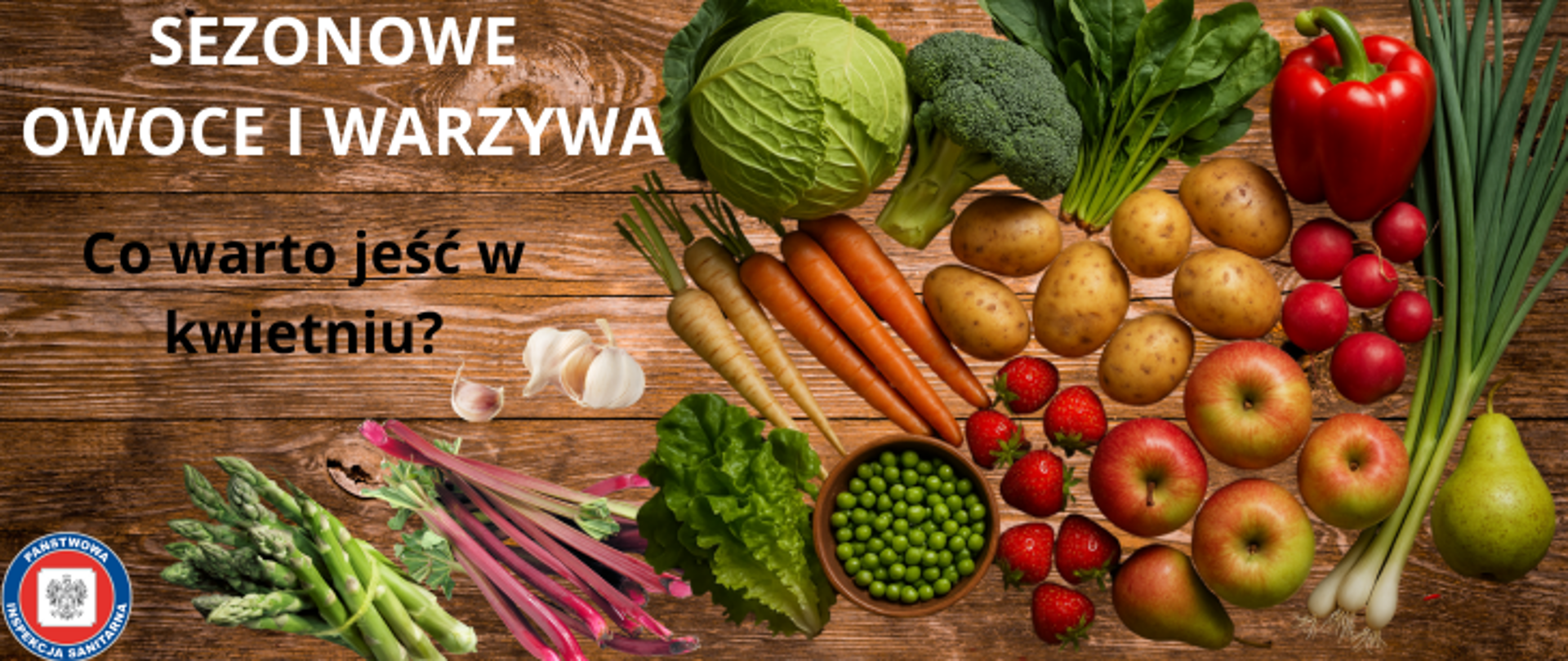 Zdjęcie przedstawia drewniany stół na którym poukładane są owoce i warzywa takie jak : kapusta, brokuł, szpinak, papryka, szczypior, pietruszka, marchewka, ziemiaki, rzodkiewka, jabłka, gruszki, truskawki, miska z zielonym groszkiem, sałata rzymska, czosnek, rabarbar, zielone szparagi. Te zdrowe przekąski to propozycje co można jeść w kwietniu jako sezonowe warzywa i owoce. Po lewej stronie widnieje napis Sezonowe owoce i warzywa - co jeść w kwietniu ? w kolorze białym, w lewym dolnym rogu znajduje się logo Państwowej Inspekcji Sanitarnej. 