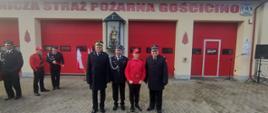 Pomorski komendant wojewódzki Państwowej Straży Pożarnej stoi z przedstawicielami ochotniczych straży pożarnych Młodzieżowej Drużyny Pożarniczej oraz strażakiem.