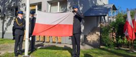 Strażacy zakładają flagę na maszt