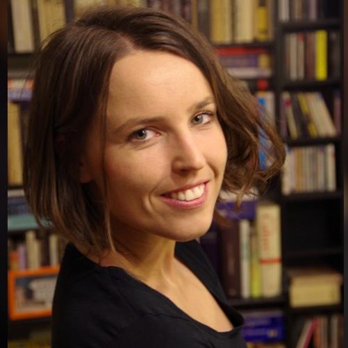 Ładnie ubrana kobieta na tle biblioteczki