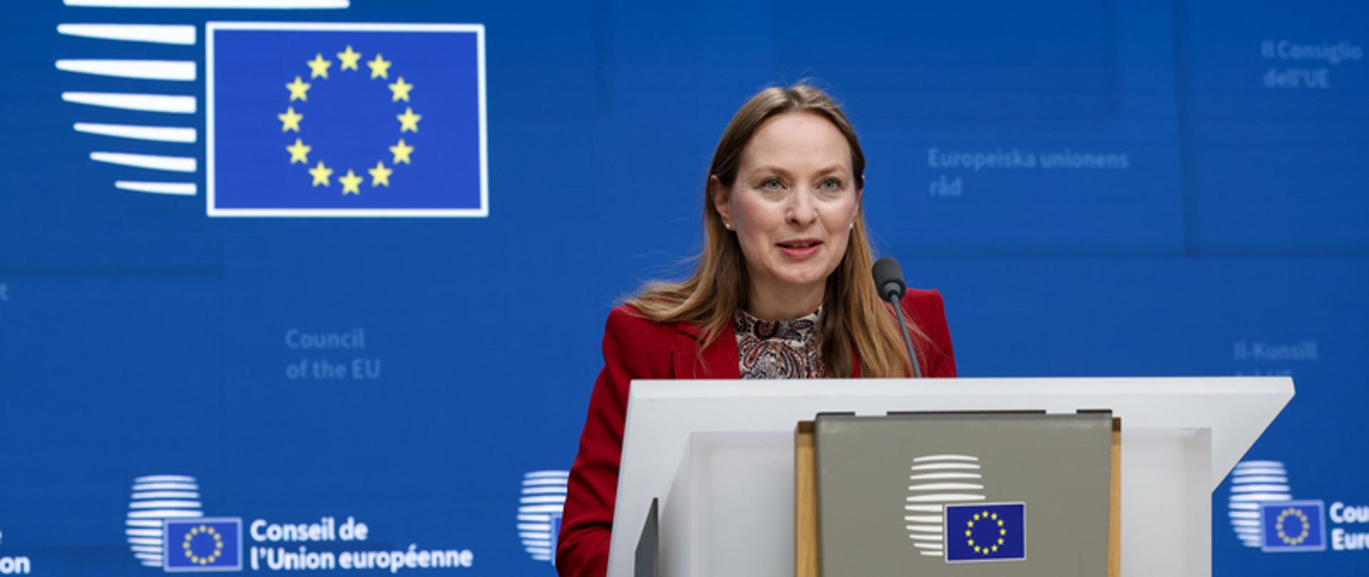 Minister funduszy i polityki regionalnej Katarzyna Pełczyńska-Nałęcz stoi przy mównicy, za jej plecami logo Rady Unii Europejskiej 