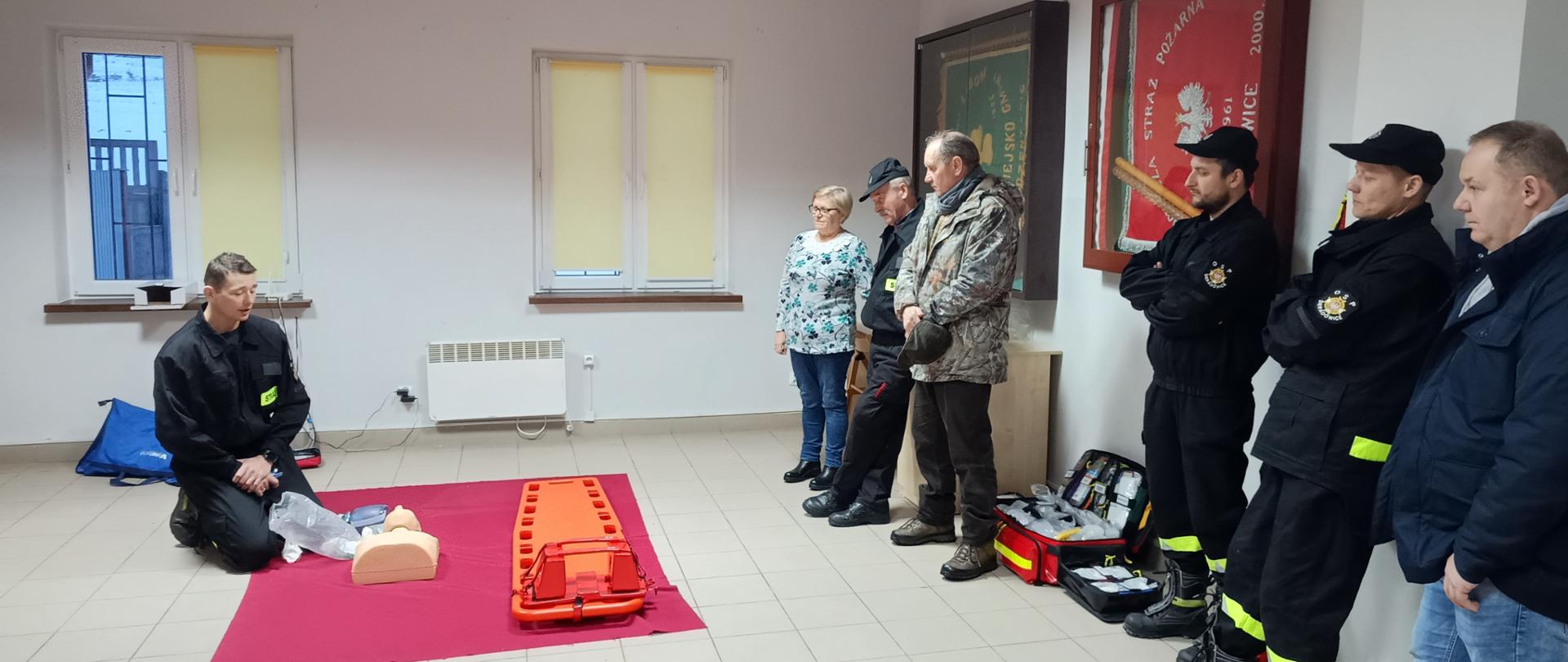 Zdjęcie przedstawia uczestników szkolenia podczas zajęć z ratownikiem medycznym – funkcjonariuszem Państwowej Straży Pożarnej w Kielcach