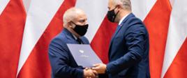Wojewoda Kujawsko-Pomorski wręcza samorządowcowi podpisaną umowę w ramach Rządowego Funduszu Rozwoju Dróg