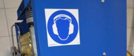 Zaplecze sprzętu ochrony układu oddechowego w Komendzie Powiatowej PSP w Rawiczu. Na planie głównym nowa sprężarka do ładowania butli. Urządzenie ma kształt prostopadłościanu. Jest koloru niebieskiego. Na zdjęciu widoczna jest tylna część kompresora.